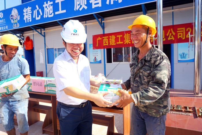 岑廷义为工人发放清冷慰问品。谢微旋 摄.jpg